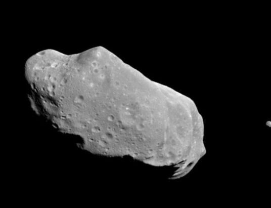 asteroid close to moon in space