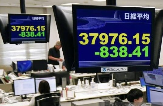 Traders in Tokyo watching screens