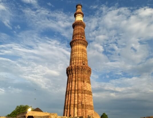 tourists in rain at qutub minar delhi