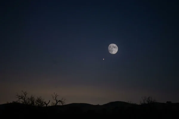 Smallest full moon of 2026 blue micromoon rising low over a dark horizon.