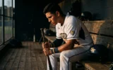 Savannah State Tigers baseball second baseman in uniform on dugout bench